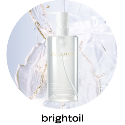 alt="Shu Uemura brightoil cleansing oiln a white pump bottle against a white circular background."