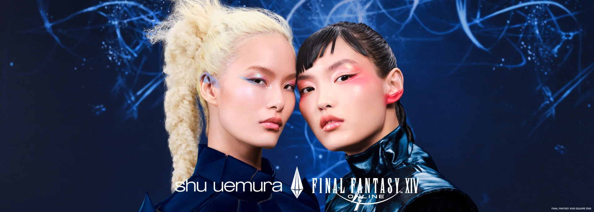 alt="Shu Uemura x Final Fantasy XIV Online campaign banner featuring two models with bold editorial makeup — one with platinum braided hair and blue eye look, the other with dark slicked hair and vivid pink eye look — posed cheek to cheek against a deep blue cosmic background."